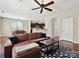 Open-concept living room with hardwood floors, a ceiling fan, and a glimpse into the kitchen and dining areas at 9507 Reid Hall Ln, Matthews, NC 28105
