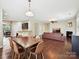Open-concept living and dining area, featuring hardwood floors and a cozy fireplace at 9507 Reid Hall Ln, Matthews, NC 28105