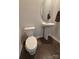 Powder room with pedestal sink, oval mirror, and toilet on hardwood floor at 9639 Margrave Dr, Gastonia, NC 28056