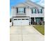 Two-story home with a spacious driveway, a two-car garage, and gray siding under a blue sky at 9639 Margrave Dr, Gastonia, NC 28056