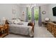 Comfortable bedroom with wooden bed frame, soft gray bedding, and natural light from the large windows at 1006 Wellington Ave, Indian Land, SC 29707