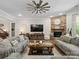 Comfortable living room featuring a stone fireplace, ceiling fan, and hardwood floors at 1006 Wellington Ave, Indian Land, SC 29707