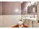 Cozy half bathroom with a pedestal sink, toilet, and wood flooring at 10407 Alvarado Way, Charlotte, NC 28277
