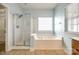 Bathroom featuring a soaking tub and glass shower at 10407 Alvarado Way, Charlotte, NC 28277