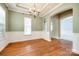 Bright dining room featuring hardwood floors, tray ceiling, chandelier, and arched doorway at 10407 Alvarado Way, Charlotte, NC 28277