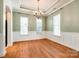 Spacious dining room with hardwood floors, tray ceiling, decorative chandelier, and three large windows at 10407 Alvarado Way, Charlotte, NC 28277