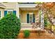 Charming covered front porch with white railings and teal shutters, framed by lush foliage at 10407 Alvarado Way, Charlotte, NC 28277