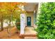 Inviting front porch with brick steps, columns, and a teal front door, surrounded by lush landscaping at 10407 Alvarado Way, Charlotte, NC 28277