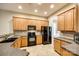 Well-lit kitchen featuring wood cabinets and modern black appliances at 10407 Alvarado Way, Charlotte, NC 28277