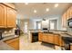 Bright kitchen featuring wood cabinets, black appliances, and an open view to the living area at 10407 Alvarado Way, Charlotte, NC 28277
