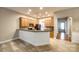 Kitchen with breakfast bar, wood cabinets, and a view into the dining area at 10407 Alvarado Way, Charlotte, NC 28277