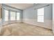 Light-filled living room with a bay window, carpet flooring, and decorative wall trim at 10407 Alvarado Way, Charlotte, NC 28277
