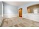 Spacious living room with carpet, arched doorway, light-blue walls, and paneled wainscoting at 10407 Alvarado Way, Charlotte, NC 28277