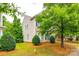 Side exterior view of a home with light siding, green shutters, and mature landscaping at 10407 Alvarado Way, Charlotte, NC 28277