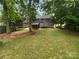A spacious backyard with a screened-in porch, a lush lawn, and mature trees. Ideal for outdoor living at 10518 Fairway Ridge Rd, Charlotte, NC 28277