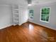 Inviting bedroom with hardwood floors, large windows, built in storage and a neutral color scheme at 10518 Fairway Ridge Rd, Charlotte, NC 28277
