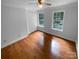 Sun-filled bedroom featuring hardwood floors, two windows, and a ceiling fan at 10518 Fairway Ridge Rd, Charlotte, NC 28277