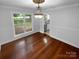 Elegant dining room featuring hardwood floors, decorative lighting, and large window with backyard view at 10518 Fairway Ridge Rd, Charlotte, NC 28277