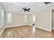 Bright bedroom with a tray ceiling, fan, and plantation shutters, showcasing hardwood floors at 11052 Preservation Park Dr, Charlotte, NC 28214