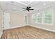 Spacious bedroom featuring a tray ceiling, fan, hardwood floors, and plantation shutters at 11052 Preservation Park Dr, Charlotte, NC 28214