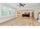 An open living room boasts wood floors, natural light, neutral colors, and an opening to the kitchen at 11052 Preservation Park Dr, Charlotte, NC 28214