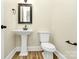 A powder room with a pedestal sink and toilet, and oil rubbed bronze fixtures at 11052 Preservation Park Dr, Charlotte, NC 28214