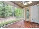 Screened porch features a ceiling fan, wood floors, and wooded views at 11052 Preservation Park Dr, Charlotte, NC 28214