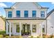 Inviting front porch with black double doors, a modern metal roof, and white columns at 1149 Rosecliff Dr, Waxhaw, NC 28173
