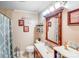 Bathroom vanity with framed mirror and decorative wall decor above a white toilet at 1204 N 12Th St, Bessemer City, NC 28016
