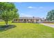 Charming single-story home with a well-maintained lawn, mature tree and American flag at 1204 N 12Th St, Bessemer City, NC 28016