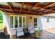 Relaxing covered back deck showcasing an open beamed ceiling, seating, and an outdoor grill perfect for entertaining at 1276 Beechwood Dr, Newton, NC 28658