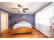Comfortable bedroom with blue walls, a ceiling fan, hardwood floors, and a large window at 1276 Beechwood Dr, Newton, NC 28658