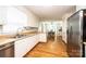 Well-lit kitchen with stainless steel dishwasher, refrigerator, light countertops, hardwood floors, and sink at 1276 Beechwood Dr, Newton, NC 28658