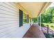 Charming covered front porch showcasing wood flooring, white pillars, and green shutters, perfect for relaxing at 1276 Beechwood Dr, Newton, NC 28658