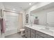 Bathroom with double sinks, light grey cabinets, a shower and tub with tile flooring at 15023 Longmoore Dr, Charlotte, NC 28278