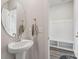Contemporary bathroom with a pedestal sink and a view into the mud room with storage at 15023 Longmoore Dr, Charlotte, NC 28278
