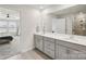 Bathroom featuring double sinks, gray cabinetry, tile flooring, and a glass shower with a view to the bedroom at 15023 Longmoore Dr, Charlotte, NC 28278
