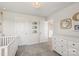 Well lit baby room with white walls, and a white dresser and crib at 15023 Longmoore Dr, Charlotte, NC 28278