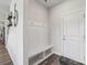 Bright entryway with modern coat rack and bench, leading to hardwood floors and stylish decor at 15023 Longmoore Dr, Charlotte, NC 28278