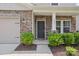 Charming front entrance featuring a dark front door flanked by green shrubs and brick accents at 15023 Longmoore Dr, Charlotte, NC 28278