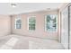 Bright bedroom with neutral walls, three windows, plush carpeting, and a closet at 1503 Stoney Ct, York, SC 29745