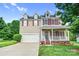 Charming two-story home featuring a front porch, manicured lawn, and attached garage at 1503 Stoney Ct, York, SC 29745