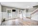 Bright living room with modern wainscoting, wood-look floors, and a view of the staircase and front yard at 1503 Stoney Ct, York, SC 29745
