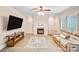 Inviting living room with fireplace, large TV, wood-look flooring, a ceiling fan, and natural light at 1503 Stoney Ct, York, SC 29745