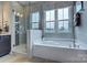 Bright bathroom featuring a soaking tub, glass shower, and neutral tile at 18145 Sulton Ter, Huntersville, NC 28078