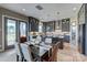 Open-concept kitchen with gray cabinets, island seating, stainless appliances, and view of the dining area at 18145 Sulton Ter, Huntersville, NC 28078