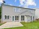 Backyard with gray siding, large windows, patio area, and green grass at 18414 Victoria Bay Dr, Cornelius, NC 28031