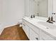 Bathroom featuring double sinks, white cabinetry, and neutral tile flooring at 18414 Victoria Bay Dr, Cornelius, NC 28031