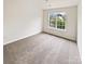 Inviting bedroom with large window, carpet, and natural light at 18414 Victoria Bay Dr, Cornelius, NC 28031