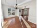 Sunlit dining room featuring hardwood floors, wainscoting, and elegant light fixtures at 18414 Victoria Bay Dr, Cornelius, NC 28031